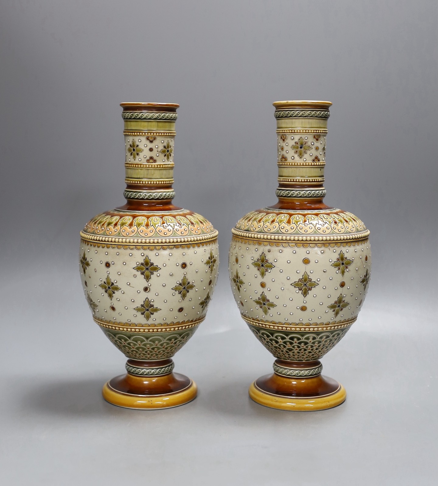 A pair of late 19th century Mettlach vases, 26 cms high.